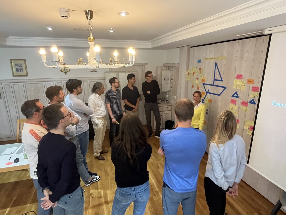 Executive team working through a structured retrospective exercise mapping risks and momentum on a wall of notes