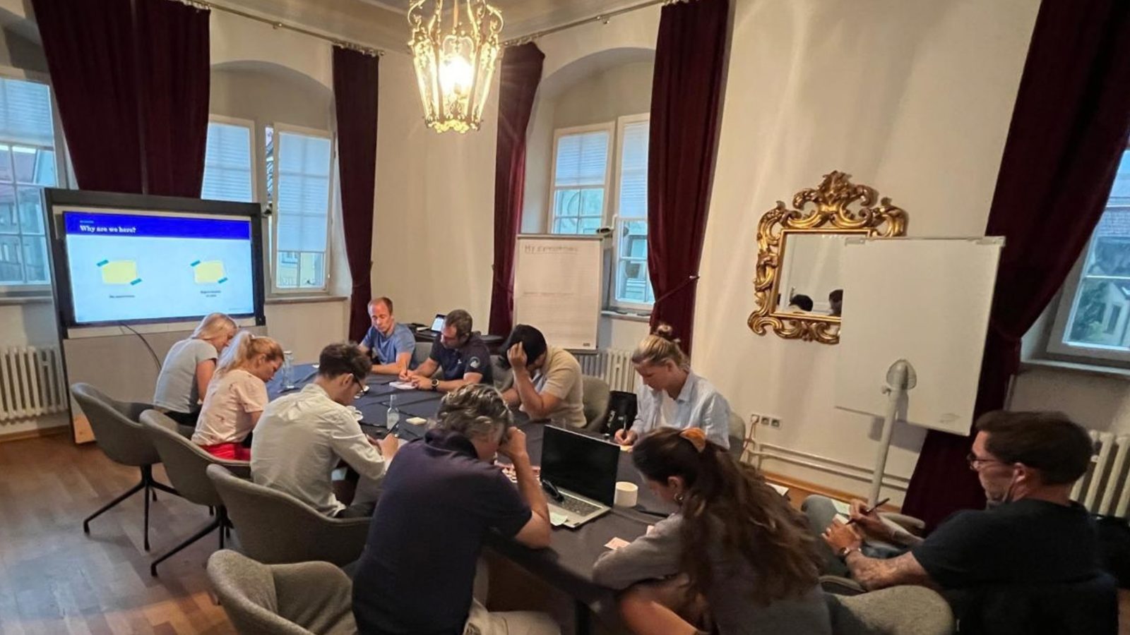 A leadership team writing individually around a table during a closed-door working session